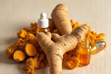 Rădăcini de turmeric și ghimbir proaspete, alături de extracte lichide în sticle, ilustrând puterea vindecătoare a plantelor.